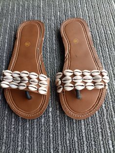 Unique Gift | Sandals | Gladiator Sandals | Greek Sandals | Beach Jewelry | Wedding Shoes | Leather Sandals | Custom | Mothers Gift An elegant and authentic pair of African inspired beaded ladies sandals, with a unique and eye-catching design. 100% genuine leather. Color -Cowrie Sea shells.   *100%  Handmade.    S I Z E  C H A R T  EUUSAUKCMINCHES 343.51.522.38.8 354.52.5239 365323.69.3 376424.29.5 387524.99.8 398625.510 4096.526.110.3 4110726.810.6 4211827.510.8 4312928.211.1   ♥ you could also Beach Toe Ring Sandals With Round Toe, White Closed Toe T-strap Sandals For Beach, White Beaded Beach Sandals, White Beaded Sandals For Beach, Flat Toe Ring Sandals For Beach, Beaded Flat Sandals For Beach, Beaded Flat Heel Sandals For Beach, Beaded Flat-heel Sandals For The Beach, White Beaded Open Toe Sandals