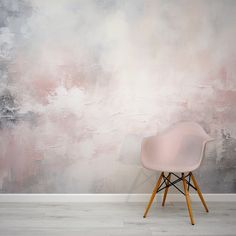 a white chair sitting in front of a wall with pink and grey paint on it