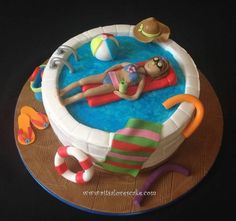 a cake that is shaped like a woman in a pool with toys on the side