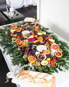 a table topped with lots of different types of food on top of a white table cloth