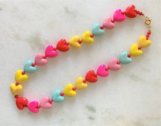 "Kids Brite Multi Colored Plastic Heart Necklace with Red Mini Spacer Beads Gold Tone Spring Ring Clasp Closure Brite Multi Hearts are Red, Hot Pink, Pink, Aqua, Yellow Hearts Measure 5/8\" Wide Necklace Measures 15\" Imported COMPLIMENTARY DOMESTIC SHIPPING" Yellow Hearts, Yellow Heart, Colorful Heart, Pink Pink, Red Hot, Spacer Beads, Spring Rings, Heart Necklace, Multi Colored