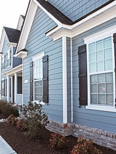 a row of houses with blue siding and white trim