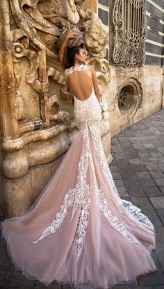 a woman in a wedding dress leaning against a wall