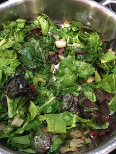 a metal pot filled with lots of green vegetables