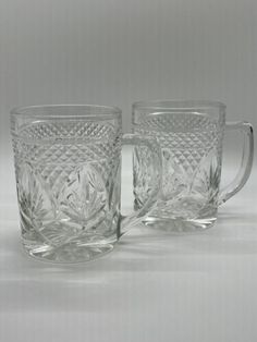 two glass mugs sitting next to each other