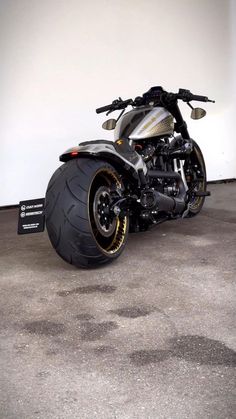 a motorcycle parked in a garage next to a white wall