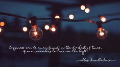 some lights that are hanging from a wire with the words happiness can be found in the daylight