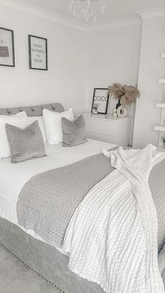 a bedroom with white walls and gray bedding