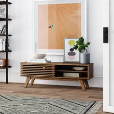 a living room scene with focus on the coffee table and art hanging on the wall