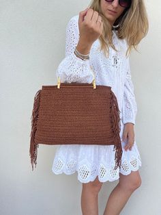 This bag with macramé cord fringes is perfect as a day bag or as a beach bag. The fringes give an extra touch to the bag and make it super trendy. Furthermore, the bamboo handles are very light and comfortable to carry by hand. The bag is handmade crochet, with quality Italian yarns. DETAILS: Material: 100% Thai cord COLOR: Brown Care: Clean stains with a damp cloth. Pat to remove excess water. Dry air. For any further information do not hesitate to contact us. With Love, Valeria and Roberta Large Drawstring Bag, Stile Boho Chic, Brown Glitter, Handmade Crochet Bags, Dry Air, Macrame Bag, Bamboo Handles, Day Bag, Style Boho