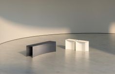 an empty room with two white cubes on the floor