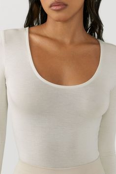 Slightly cropped long sleeve top with a wide scoop neckline and fitted sleeves. This modal long sleeve is ultra comfortable, softer than soft, and breathable. It's a hard-to-beat trio in our famous modal fabric. You'll live in it, and we don't blame you. Color: Chalk Sizing: X/S (0-2), S/M (4-6), M/L (8-10) MODEL IS 5'8" AND WEARING SIZE X/S Fabric: 95% Micro Modal, 5% Spandex Care: Hand Wash Cold. Lay Flat to Dry. Made in Los Angeles Seamless Scoop Neck Crop Top, Seamless Scoop Neck T-shirt For Loungewear, Black Long Sleeve Scoop Neck, Joah Brown Sweatshirt, Joah Brown Long Sleeve, Cropped Long Sleeve Top, Scoop Neckline, Basic Tank Top, Scoop Neck