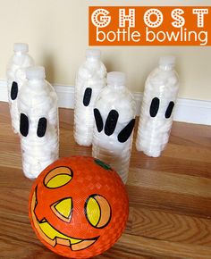 an orange ball with black dots on it sitting next to some plastic bottles and pumpkins