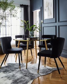 a dining room table with chairs and a rug on the floor in front of it