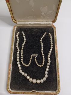 This vintage necklace is a classic beauty that will add elegance to any outfit. Made of high-quality sterling silver with a single strand of natural white pearls, this necklace has a length of 18-19.99 inches and features a round pendant shape. The necklace has a feminine style and is perfect for females who want to add a touch of sophistication to their look. It also comes with a box for safekeeping. The metal purity is 925 and the secondary stone is also a pearl. Adjustable Silver Vintage Pearl Necklace, Vintage Pearl White Pearl Necklace Gift, Vintage Pearl Necklaces With Rhinestones, Vintage Cream Single Strand Pearl Necklace, 1940s Pearl Necklace, Round Pendant, Classic Beauty, Fine Jewellery Necklace, Feminine Style