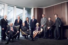 a group of people in suits and ties posing for a photo inside an office building