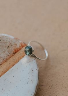 Our Dori ring is made with a gorgeous Labradorite stone. This mystical gemstone is believed to enhance mental clarity and bring about transformation. It's a crystal connected to the third eye chakra which is our gateway to inner wisdom and deeper intuition. 8mm round or 6x8mm oval labradorite stone. Ring band measures 1mm wide. Available in 14kt Gold Fill + Sterling Silver. Juliann stacks it with our Swell Ring and 2 Confetti Rings. KJ pairs it with our Sonder Ring, Raye Ring, and Confetti Ring. Confetti Ring, Copper Uses, Everyday Wear Jewelry, Backdrops Necklace, Zodiac Rings, The Third Eye, Hoop Charms, Inner Wisdom, Third Eye Chakra