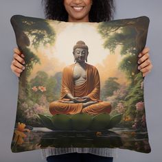 a woman holding up a pillow with a buddha painting on it