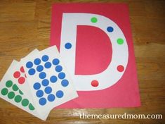 the letter d is made out of paper with dots on it and two matching cards