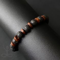 LAVA STONE BRACELET WITH WOODEN BEAD BRACELET FOR MEN ♥ GROUNDING ♥ CONNECTION ♥ SPIRITUALITY ♥ STRENGTH ♥ POSITIVITY Embrace the earthy elegance of the LAVA STONE BRACELET WITH WOODEN BEAD BRACELET FOR MEN, a symbol of spiritual grounding and connection meticulously crafted by Hømo Spiritus artisans. This gemstone beaded stretch bracelet features natural Lava Stone and Wooden Beads, exuding a blend of rustic charm and spiritual energy. With hues of black and brown, this bracelet is rooted in yo Adjustable Brown Wristband With 8mm Beads, Wooden Bead Bracelet, Bead Bracelet For Men, Spiritual Grounding, Earthy Elegance, Lava Rock Bracelet, Lava Stone Bracelet, Meditation Bracelet, Black Beaded Bracelets