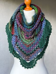 a multicolored crocheted shawl on a mannequin