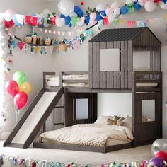 a bunk bed with a slide next to it in a room filled with balloons and streamers