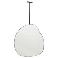 an oval shaped mirror hanging from a metal pole