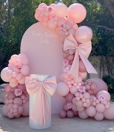 a large balloon arch with balloons and bows