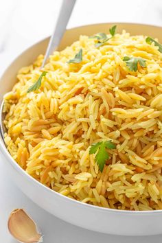 a white bowl filled with rice and garnished with parsley