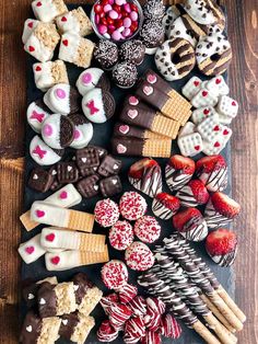 an assortment of valentine's day treats on a wooden table with chocolates and strawberries