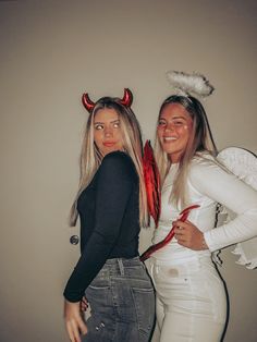 two women dressed in devil costumes posing for the camera