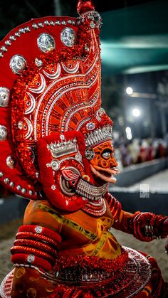 an elaborately decorated mask is displayed in front of the audience at a carnival event