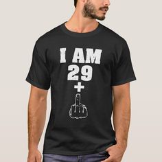 a man wearing a black t - shirt with the words i am 29 plus on it