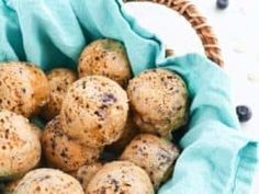 a basket filled with blueberries and muffins covered in brown sprinkles