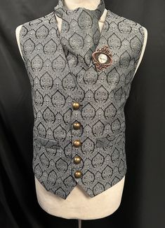 Steampunk Vest Brocade Waistcoat Gothic Renaissance This is a stunning black / grey  waist coat with a vintage design  It is fully lined and well made. It has pockets  and adjustable back. It comes with a matching cravat and a handcrafted  rustic metal frame tie pin. Chest measurement is 2 sizes M approx 38/40 L approx 42/44 Length front approx 24" Length back approx 23" Makes a stunning steampunk gentleman's outfit!  Thank you for looking Steampunk Black Vest For Costume Party, Steampunk Black Vest For Fall, Black Steampunk Vest For Costume Party, Steampunk Style Black Vest For Costumes, Steampunk Formal Sleeveless Vest, Black Fitted Steampunk Vest, Formal Steampunk Sleeveless Vest, Vintage Winter Costume Vest, Vintage Winter Vest For Costume