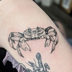 a crab tattoo on the back of a woman's shoulder