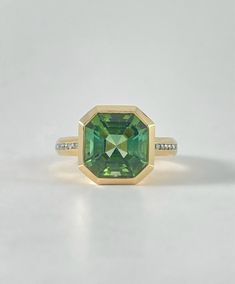 Whopper 13 ct asscher cut Tourmaline in a gorgeous moss green. 2mm chunky 18k yellow gold bezel setting with white diamond accents. Green Tourmaline 18k yellow gold white Diamond Luxury Yellow Gold Tourmaline Emerald Ring, Unique Green Tourmaline Rings, Yellow Gold Tourmaline Emerald-cut Ring, Modern Green Tourmaline Jewelry, Polished Green Tourmaline Jewelry, Phone Items, Asscher Cut, Moss Green, Green Tourmaline