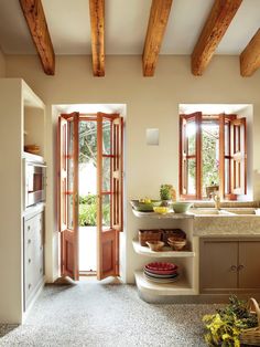 an open door leading into a kitchen with wooden ceiling beams and wood trimmings