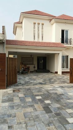 a large house with a motorcycle parked in front of it and an open door leading to the outside