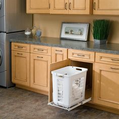 a kitchen with wooden cabinets and white laundry basket