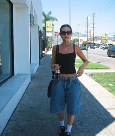 a woman standing on the sidewalk with her hand in her pocket