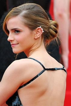 the back of a woman's dress at an oscars event with her hair in a pony tail