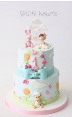 a three tiered cake decorated with fondant and teddy bears on it's sides