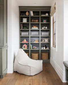 a white bean bag chair sitting in front of a bookshelf filled with shelves