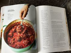 the cookbook is open to show an image of a person cooking in a pot