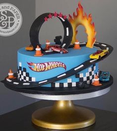 a birthday cake with cars on top and flames coming out of the car's tires