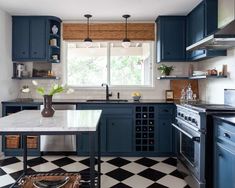 a kitchen with blue cabinets and black and white checkered flooring on the walls