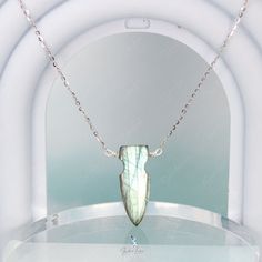 This one-of-a-kind arrow Labradorite necklace boasts a stunning arrow-shaped pendant on a sturdy 925 sterling silver chain. The wire used is also made of high-quality 925 sterling silver. The arrow-shaped Labradorite stone showcases a mesmerizing green hue with a dazzling blue flash when hit by sunlight. Make a statement by adding this handcrafted Labradorite necklace to your fine jewelry collection or give it as a gift to a special someone. Materials: Labradorite, 925 sterling silverPendant dim Handmade Sterling Silver Arrowhead Necklace, Silver Sterling Silver Arrowhead Necklace, Labradorite Necklace, Labradorite Necklaces, Stone Pendant Necklace, The Wire, 925 Sterling Silver Chain, Labradorite Pendant, Labradorite Stone