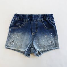 Glimmering Star & Rhinestone Denim Shorts, shimmying with star embroidery & rhinestones! Elastic waist helps you twirl, and pockets make sure you don't lose your sparkle. 100% Cotton. Embellished Dark Wash Denim Bottoms, Casual Stretch Embellished Bottoms, Casual Embellished Stretch Bottoms, Casual Stretch Bottoms With Rhinestones, Casual Medium Wash Rhinestones Bottoms, Summer Denim Blue Star Print Bottoms, Denim Blue Summer Bottoms With Star Print, Denim Star Print Shorts, Rhinestone Denim