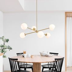 a dining room table with chairs and a light fixture hanging from the ceiling over it